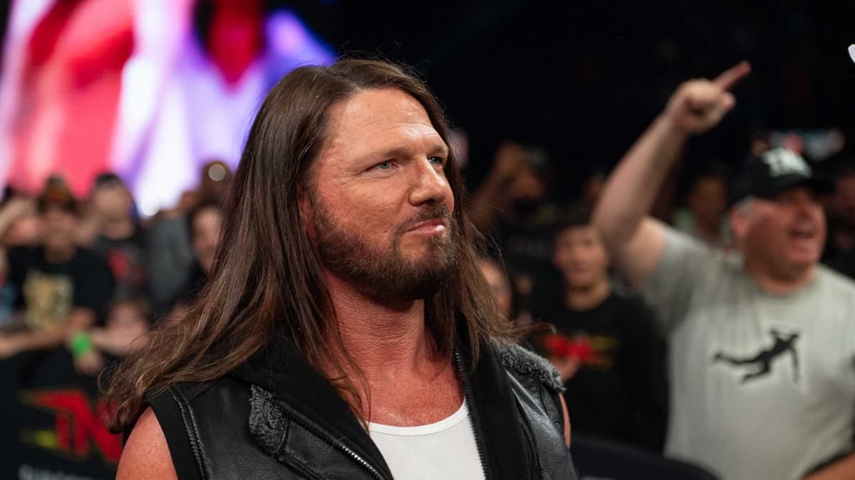 AJ Styles smiling while wearing a white vest and leather jacket vest at TNA Slammiversary 2025